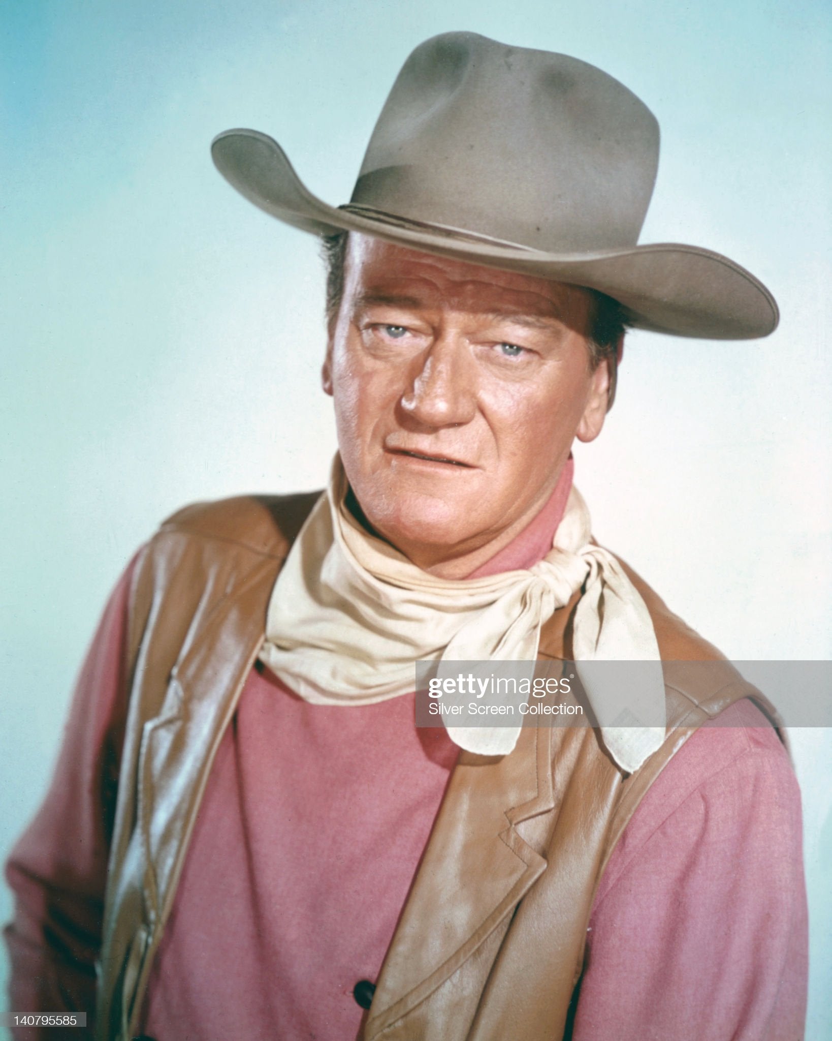 John Wayne - man not afraid of a pink shirt. Silver Screen Collection Getty Images © Studio portrait, against light blue background circa 1970.